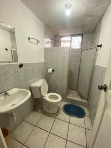 uma casa de banho com um WC, um lavatório e um chuveiro em Hostal Almagro em Quito