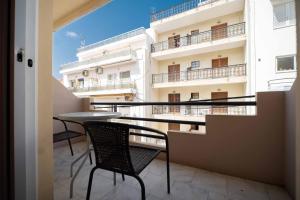 a balcony with a table and chairs in front of a building at Dimitris City Break Apts in Chania Town