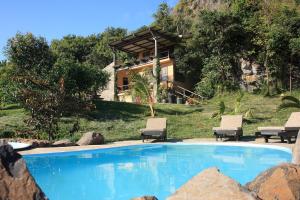 a swimming pool in front of a house at La Hacienda Mauritius in Mahébourg