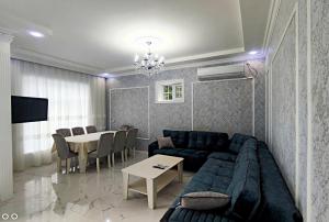 uma sala de estar com um sofá azul e uma mesa em Qafqaz Manor Zabbix em Gabala