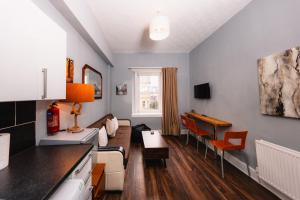 a living room with a couch and a table at Warm&Welcoming City Centre Apartments by Meadows 10 in Edinburgh