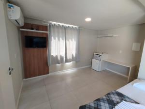 ボンビーニャスにあるPousada Bombinhas Houseのベッドとデスクが備わる客室です。