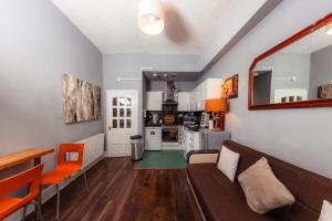 a living room with a couch and a kitchen at Warm&Welcoming City Centre Apartments by Meadows 10 in Edinburgh