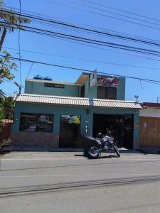 ein Motorrad, das vor einem Gebäude geparkt ist in der Unterkunft SL Hostel in Alajuela