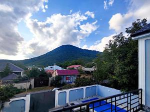uma vista para uma montanha a partir da varanda de uma casa em Qafqaz Manor Zabbix em Gabala