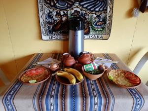 una mesa cubierta con platos de comida en una mesa en Uros Tupirmarka Lodge Perú, en Puno