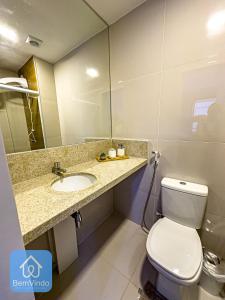 a bathroom with a toilet and a sink and a mirror at Studio charmoso no coração da Barra in Salvador