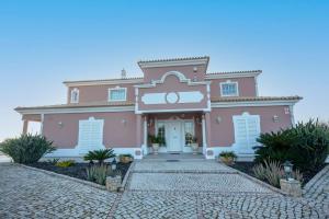 una casa rosa con una entrada delante de ella en Al Meida Guesthouse en Albufeira
