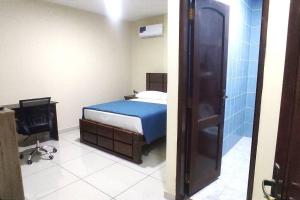 Schlafzimmer mit einem Bett, einem TV und einer Dusche in der Unterkunft Céntrico Estudio Cruceño A/C 2 in Santa Cruz de la Sierra