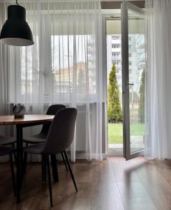 a dining room with a table and chairs and a window at Apartament Przy Obserwatorium&Singielnia in Olsztyn