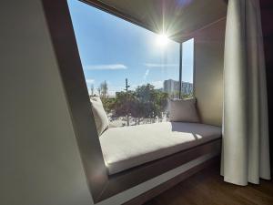 asiento junto a la ventana con vistas a la playa en Hotel SB Win, en Sant Feliu de Llobregat