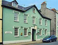 ein grünes Haus mit einem davor geparkt in der Unterkunft Bishopsgate House Hotel in Beaumaris