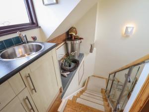 una piccola cucina con lavandino e scala di Highgate a Llandudno Altre 30 foto