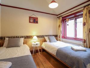 a bedroom with two beds and a window at Highgate in Llandudno