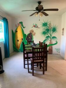 a dining room with a table and chairs with a pineapple mural at Casa Redonda Hostal Inn 1 in Holbox Island