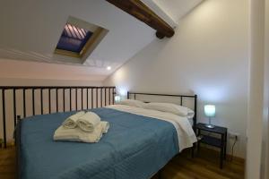 a bedroom with a bed with towels on it at XX Miglia apartments in Catania