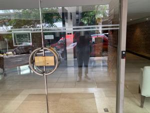 a reflection of a person in the window of a store at Lindisimo en Recoleta in Buenos Aires
