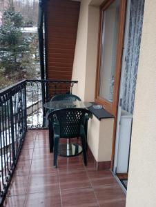 un balcón con mesa y sillas en el porche en Willa Babia Góra, en Zawoja