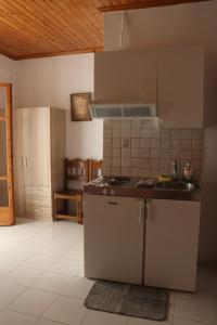 kuchnia z kuchenką i zlewem w obiekcie Kondilw Rooms w mieście Kalamitsi