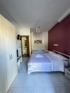 1 dormitorio con 1 cama grande y pared roja en La Piazzetta Fittacamere en Torella deʼ Lombardi