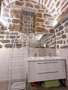 uma casa de banho branca com um lavatório e uma escada em Gîte XIIIème siècle - 3étoiles - WIFI - Salle de sport em Osse-en-Aspe
