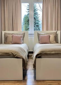 two beds in a room with a window at Apartament Przy Obserwatorium&Singielnia in Olsztyn