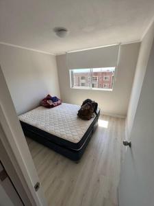 een slaapkamer met een bed in een kamer met een raam bij Apartamento en Cartagena Valparaíso in Cartagena