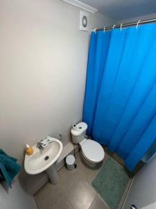 een badkamer met een wastafel, een toilet en een blauw douchegordijn bij Apartamento en Cartagena Valparaíso in Cartagena