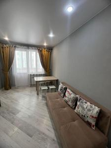 een woonkamer met een bank en een tafel bij Nureke Apartment's in Alma-Ata