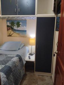 1 dormitorio con 1 cama y 1 mesa con lámpara en Nely y Pietro share apartment, en Punta Cana