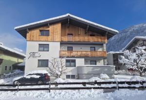 a building with a car parked in the snow at Flo's Apartment in Grossarl