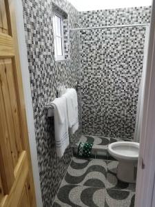 baño con aseo y pared de azulejos en Thebreeze can accommodate up to 30 people, 