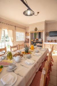 una sala da pranzo con un lungo tavolo con tovaglia bianca di Al Meida Guesthouse ad Albufeira