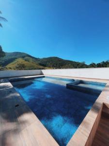 uma piscina com água azul numa casa em Sítio com piscina incrível em Santo Amaro da Imperatriz