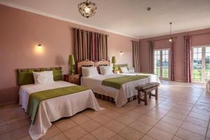 Habitación de hotel con 2 camas y lámpara de araña. en Al Meida Guesthouse en Albufeira