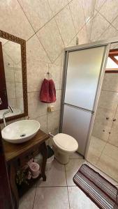 uma casa de banho com um chuveiro, um WC e um lavatório. em Sítio com piscina incrível em Santo Amaro da Imperatriz