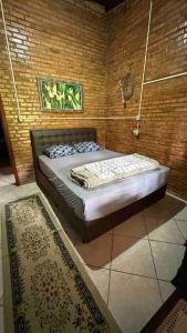 - une chambre avec un lit dans une pièce dotée d'un tapis dans l'établissement Sítio com piscina incrível, à Santo Amaro da Imperatriz