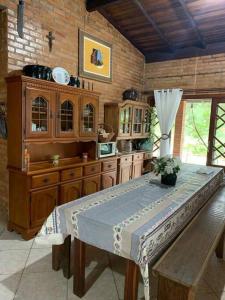 uma cozinha com mesa e armários de madeira em Sítio com piscina incrível em Santo Amaro da Imperatriz