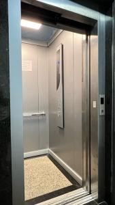 un ascensore in un edificio con porta in vetro di Apartamento sem vista ao mar, à 15 metros da praia de Piúma a Piúma