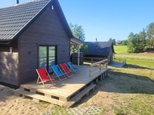 een groep stoelen op het dek van een cabine bij APANÓWKA domki z balią jacuzzi 