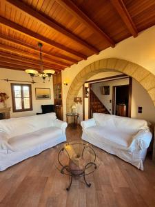 ein Wohnzimmer mit 2 weißen Betten und einem Tisch in der Unterkunft Suite del Capitano in Rhodos (Stadt)