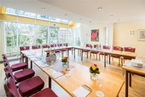 una gran sala de conferencias con una mesa larga y sillas en Wassermühle Heiligenthal, en Lüneburg