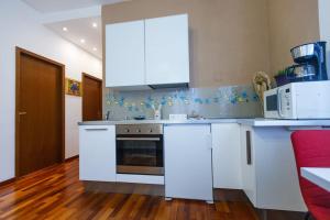 a white kitchen with white cabinets and a microwave at Venice-Flat 75m² perfect for 2 couples (free Park) in Mestre