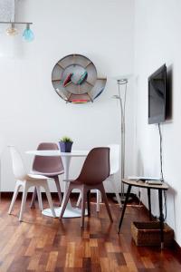 a dining room with a table and chairs and a clock at Venice-Flat 75m² perfect for 2 couples (free Park) in Mestre