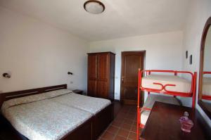 a bedroom with a bed and a table and a chair at AGRITURISMO LA FATTORIA in Ranzo-Borgo