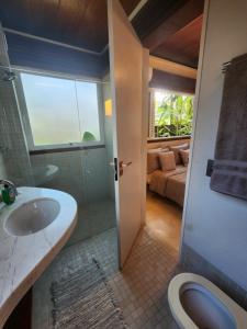 a bathroom with a sink and a shower and a toilet at Salt 'n Paradise Luxury Surf and Beach Suites in Ubatuba