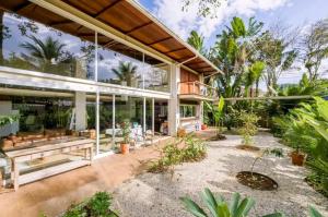 a large glass house with a lot of plants at Salt 'n Paradise Luxury Surf and Beach Suites in Ubatuba +39 photos