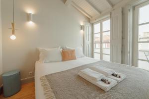 ポルトにあるDeluxe Duplex by Hostyのベッドルーム1室(白いベッド1台、タオル付)