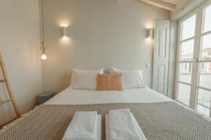 ポルトにあるDeluxe Duplex by Hostyのベッドルーム1室(大きな白いベッド1台、枕2つ付)
