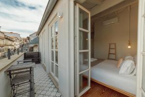 a balcony with a bed and a window at Deluxe Duplex by Hosty in Porto